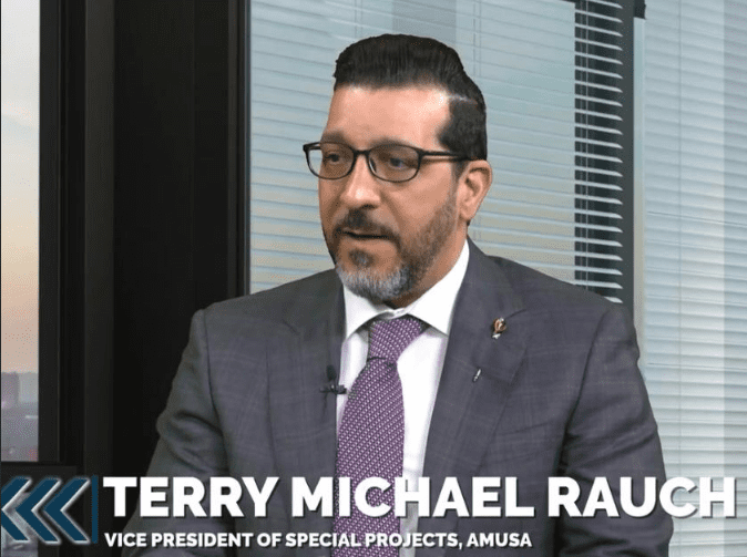 Man in suit speaking during an interview.