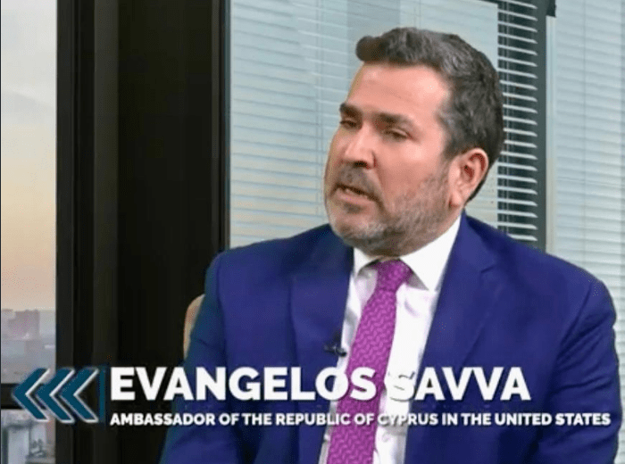 Man speaking in a suit and tie.